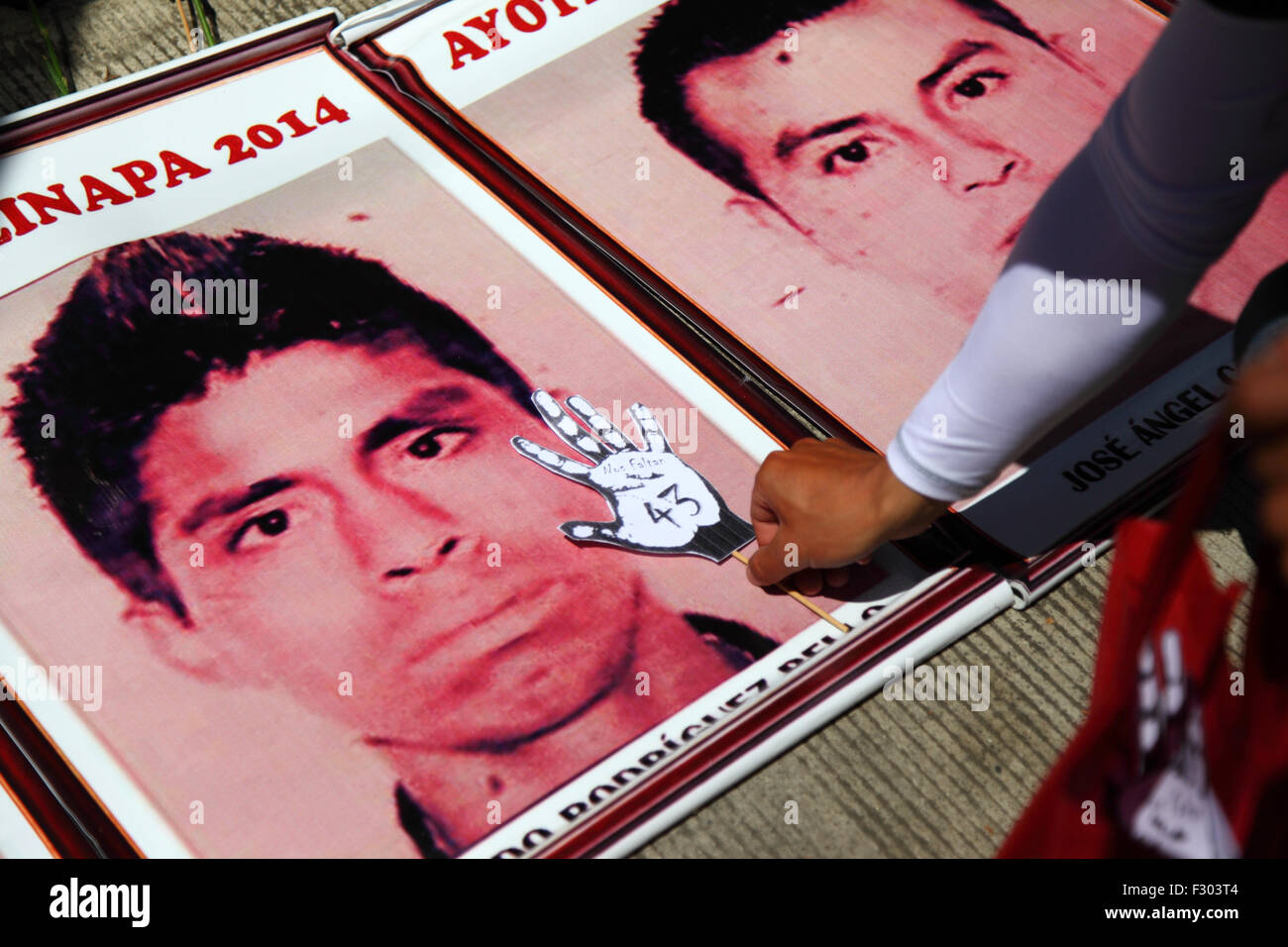 La Paz, Bolivie, le 26 septembre 2015. Un manifestant place une main de papier avec 'Nos falta 43' ('43') manque d'inscrit sur une photo de l'un des disparus les élèves à l'extérieur l'ambassade du Mexique à La Paz. Les élèves ont disparu il y a un an aujourd'hui dans la nuit du 26 septembre 2014 dans la ville d'Iguala dans l'État de Guerrero. Le gouvernement mexicain pour son traitement de l'affaire a été largement critiqué et une équipe envoyée par la Commission interaméricaine des droits de l'Homme a conclu un certain nombre de lacunes dans l'enquête du gouvernement. Banque D'Images