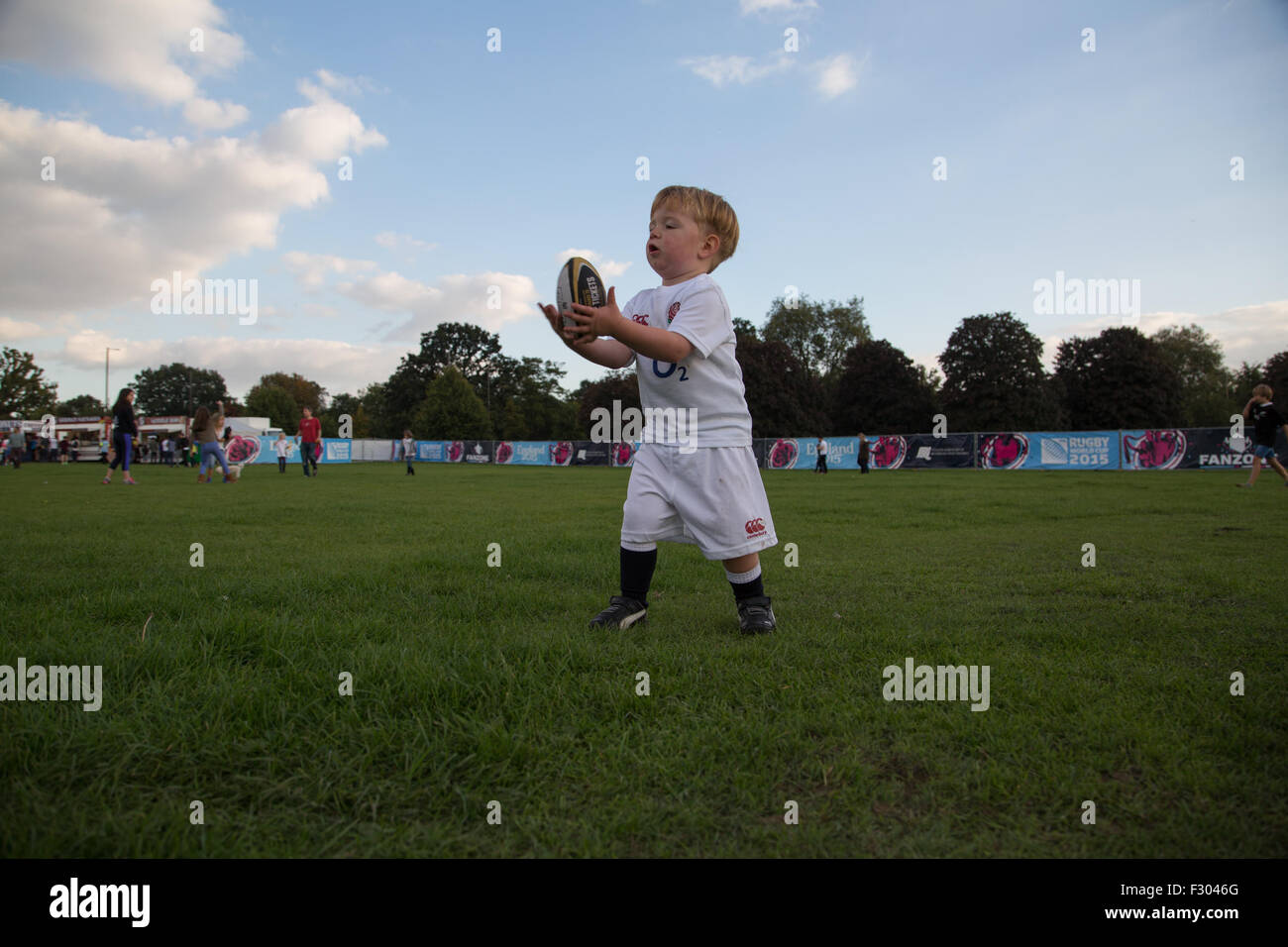 Richmond, London, UK. 26 Sep, 2015. Un enfant en pratique ses compétences avec le ballon ovale à une Coupe du Monde de Rugby en plein air le dépistage à l'Old Deer Park, Richmond, Londres SW. Des centaines de fans se sont réunis pour regarder une série de matchs sur grand écran non loin du Stade de Twickenham. Crédit : à vue/Photographique Alamy Live News Banque D'Images