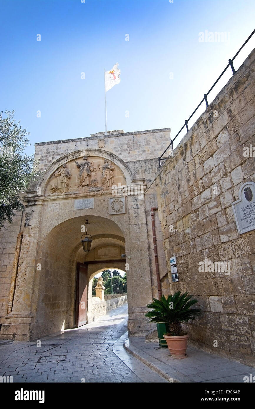 Portail d'entrée de style baroque à l'intérieur des remparts et d'un drapeau sur une journée ensoleillée dans la ville silencieuse Mdina à Malte. Banque D'Images