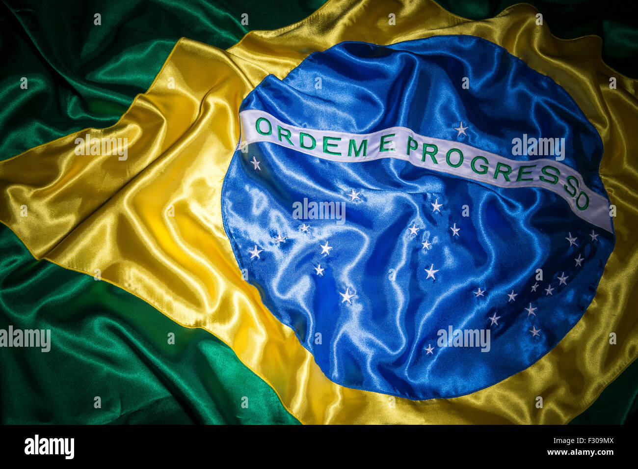 Drapeau brésilien en tissu soyeux brillant dans l'arrière-plan soyeux texturé Banque D'Images