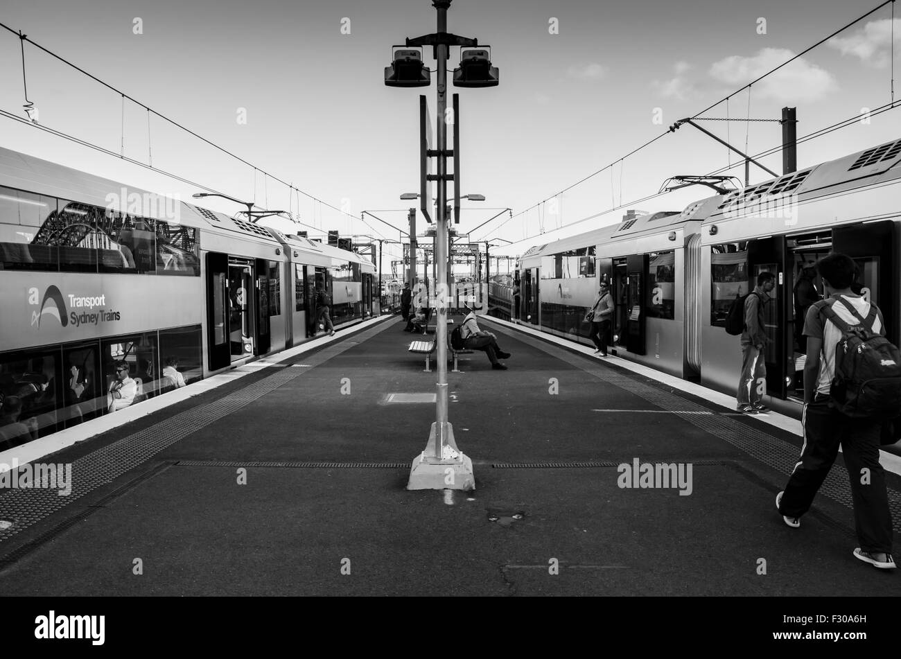 Gare de Milsons point, Sydney, novembre 2014 : les personnes qui quittent et rejoignent deux trains de Sydney de chaque côté de la plate-forme ferroviaire en Australie Banque D'Images