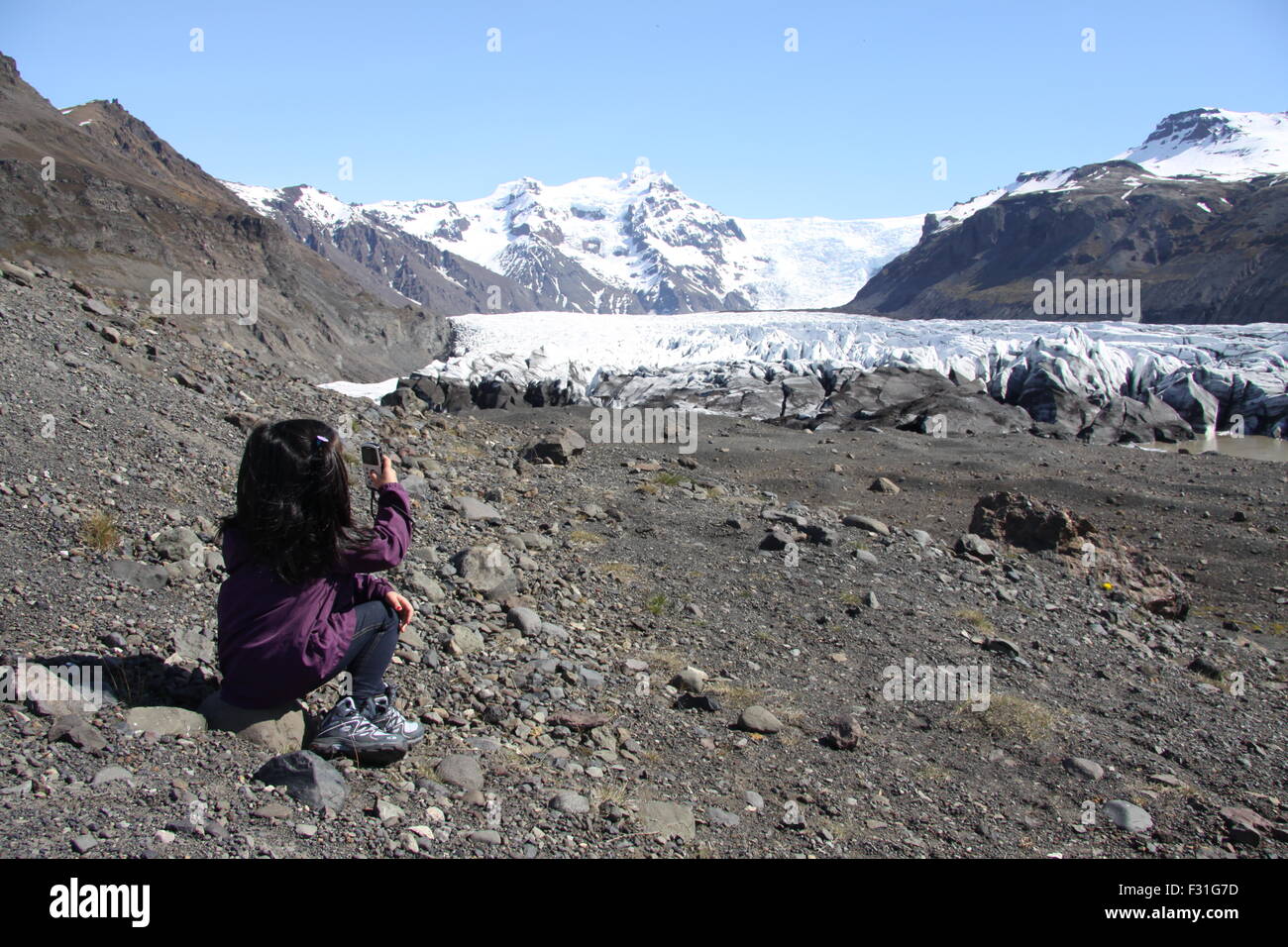 Jeune fille en prenant une photo de la fonte des glaciers de l'arm, Hvannadalshnúkur Öraefajökull volcan en Islande. Banque D'Images