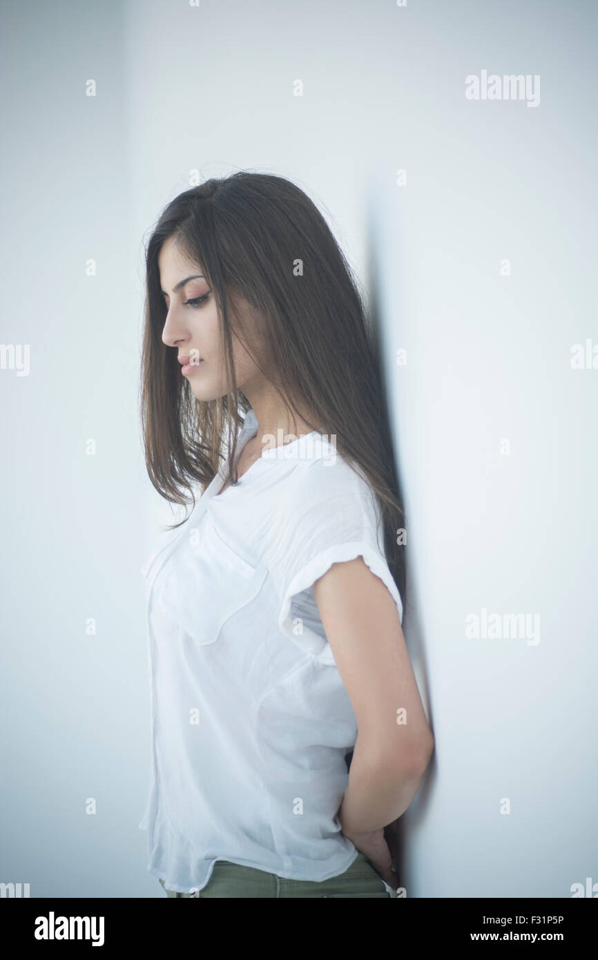 Femme triste appuyé contre le mur Banque D'Images