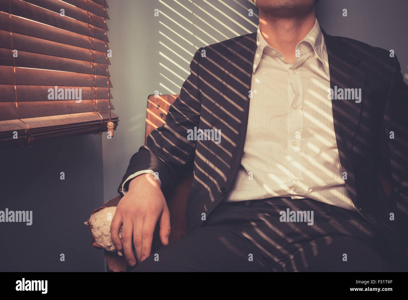 Jeune homme est reposant sur un vieux canapé par la fenêtre sur un jour ensoleillé Banque D'Images