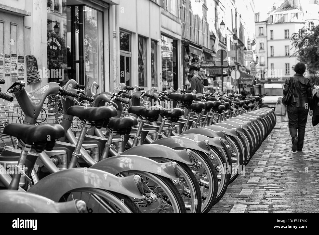 Un service de location de vélos dans une rangée dans une rue de Paris, France Banque D'Images