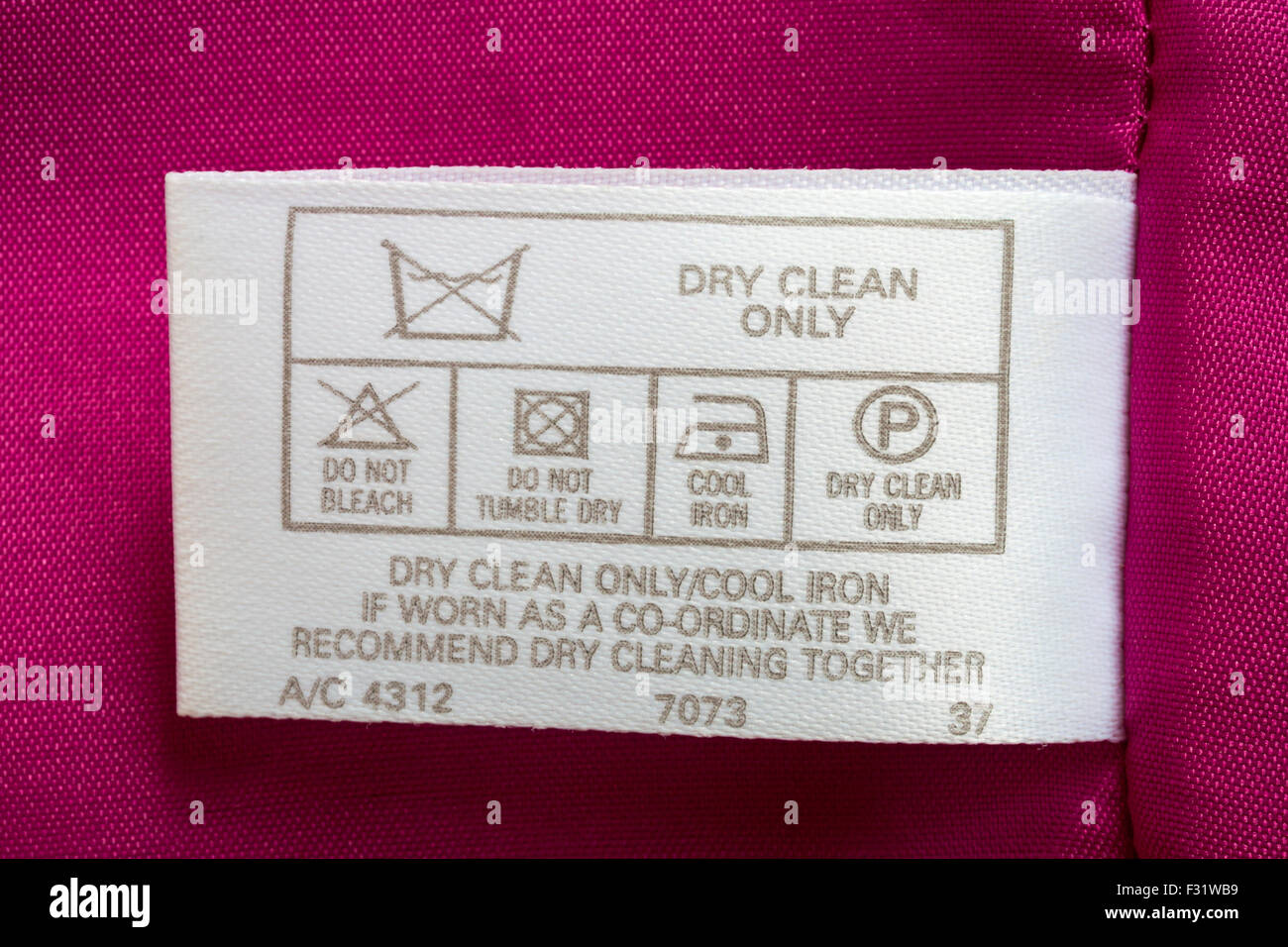 étiquette en robe rose vêtement - nettoyage à sec seulement un fer frais, si porté en coordination, nous recommandons le nettoyage à sec ensemble - symboles de lavage d'entretien Banque D'Images
