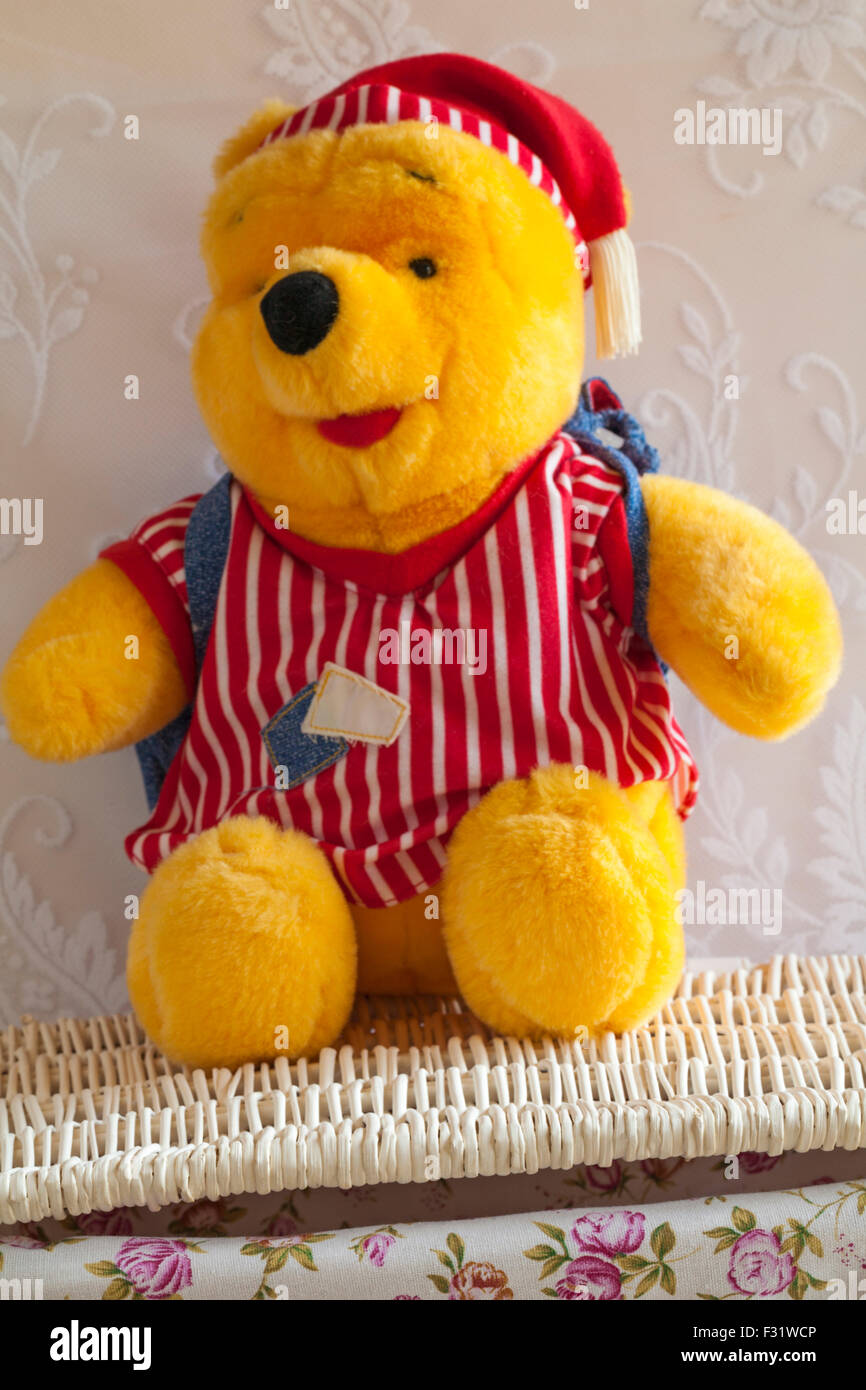 Winnie l'ourson en peluche doux ours assis sur panier en osier Banque D'Images