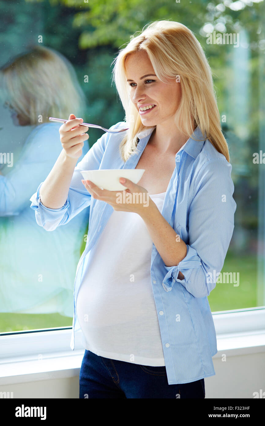 Femme enceinte 30 semaines de manger des céréales pour petit déjeuner Banque D'Images
