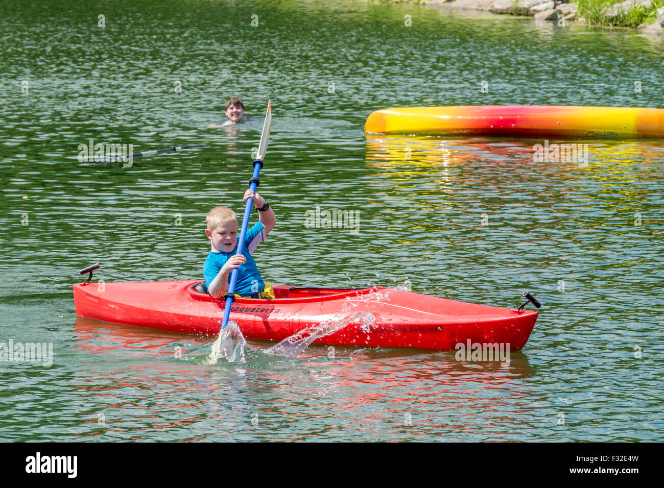 Les jeunes garçons kayak sur un lac avec une chavire Banque D'Images