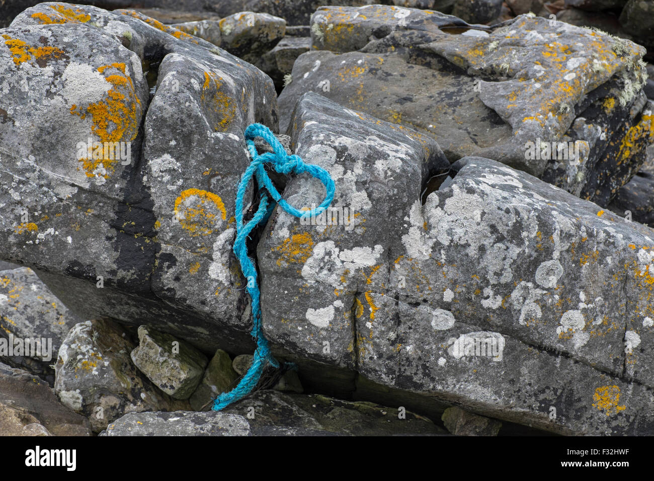 La corde de nylon pris entre les rochers sur la côte. Banque D'Images