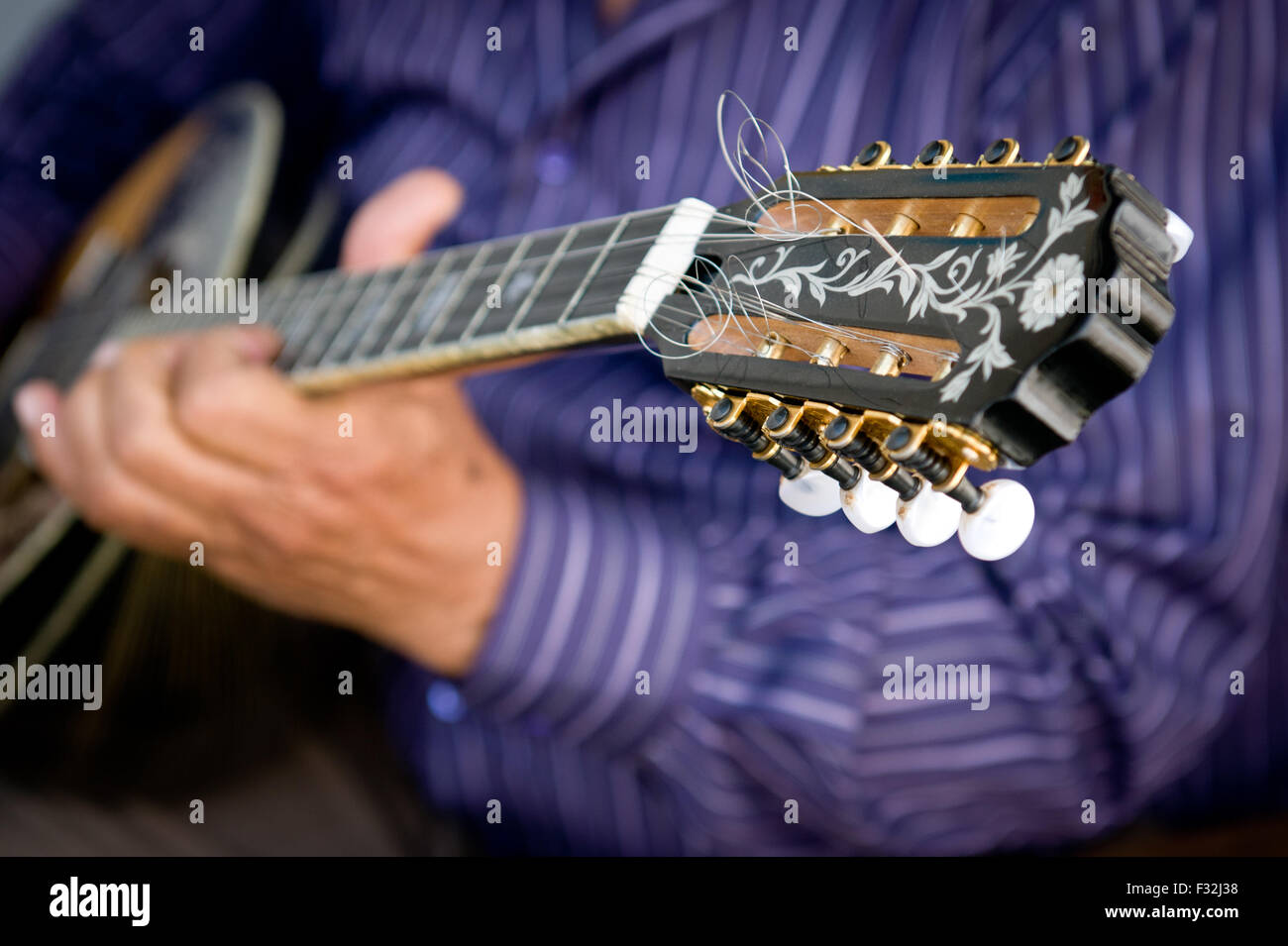 Musicien jouant d'un instrument traditionnel grec qui est long comme pouzouki appelé mandoline Banque D'Images