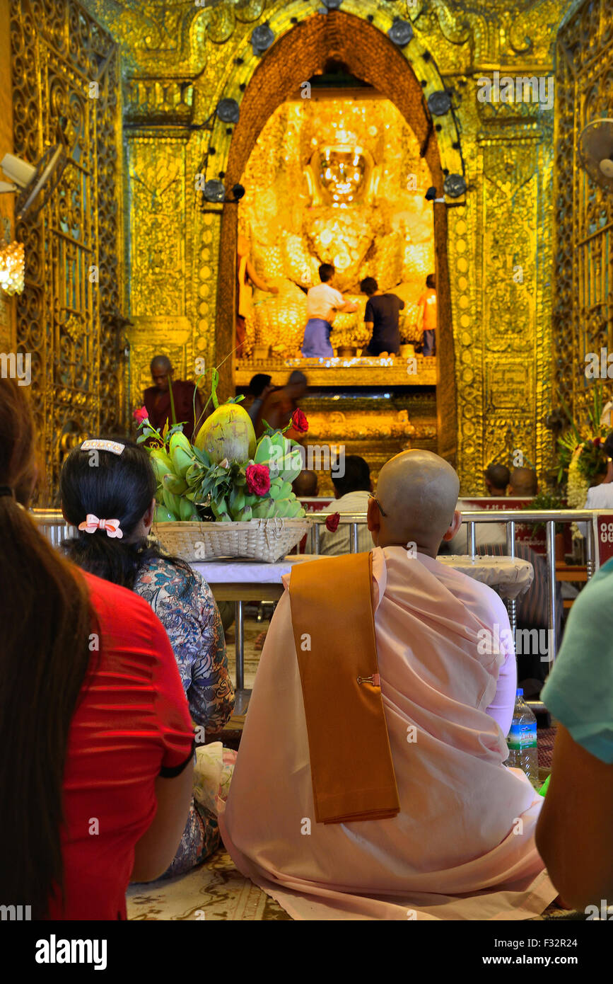 Nonne birmane et les fidèles dans le célèbre Bouddha d'or au Temple Mahamuni, Mandalay, Myanmar, la ville (Birmanie, Birmanie) Asie Banque D'Images