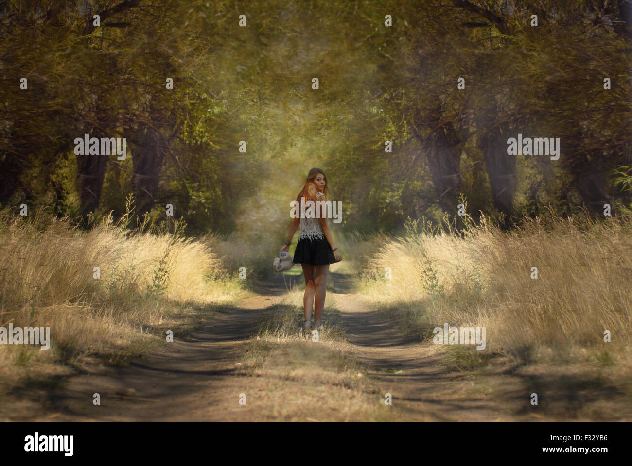 Grande fille à trouhgt la forêt à l'arrière Banque D'Images