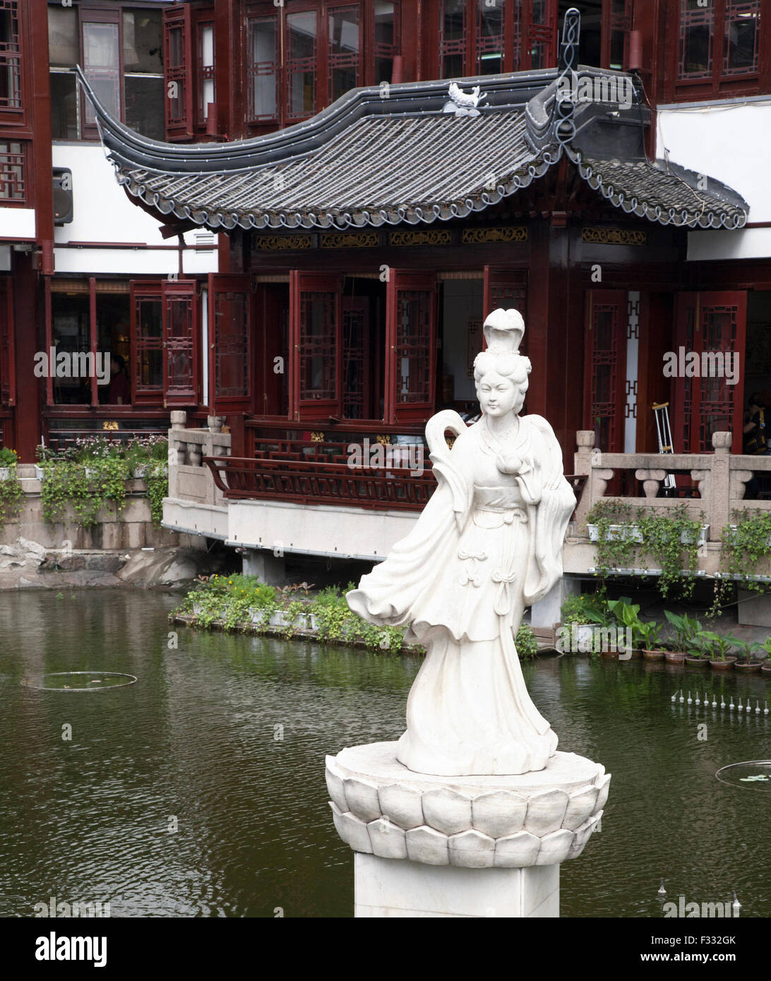 Maison de thé Huxinting et statue dans un étang à l'entrée du jardin Yuyuan dans la vieille ville de Shanghai, province de Shanghai, Chine Banque D'Images