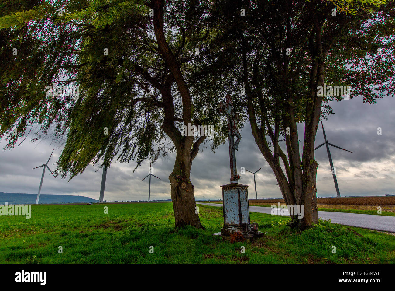 Parc d'énergie éolienne dans le domaine, peu d'autel, avec une croix à un carrefour, Banque D'Images