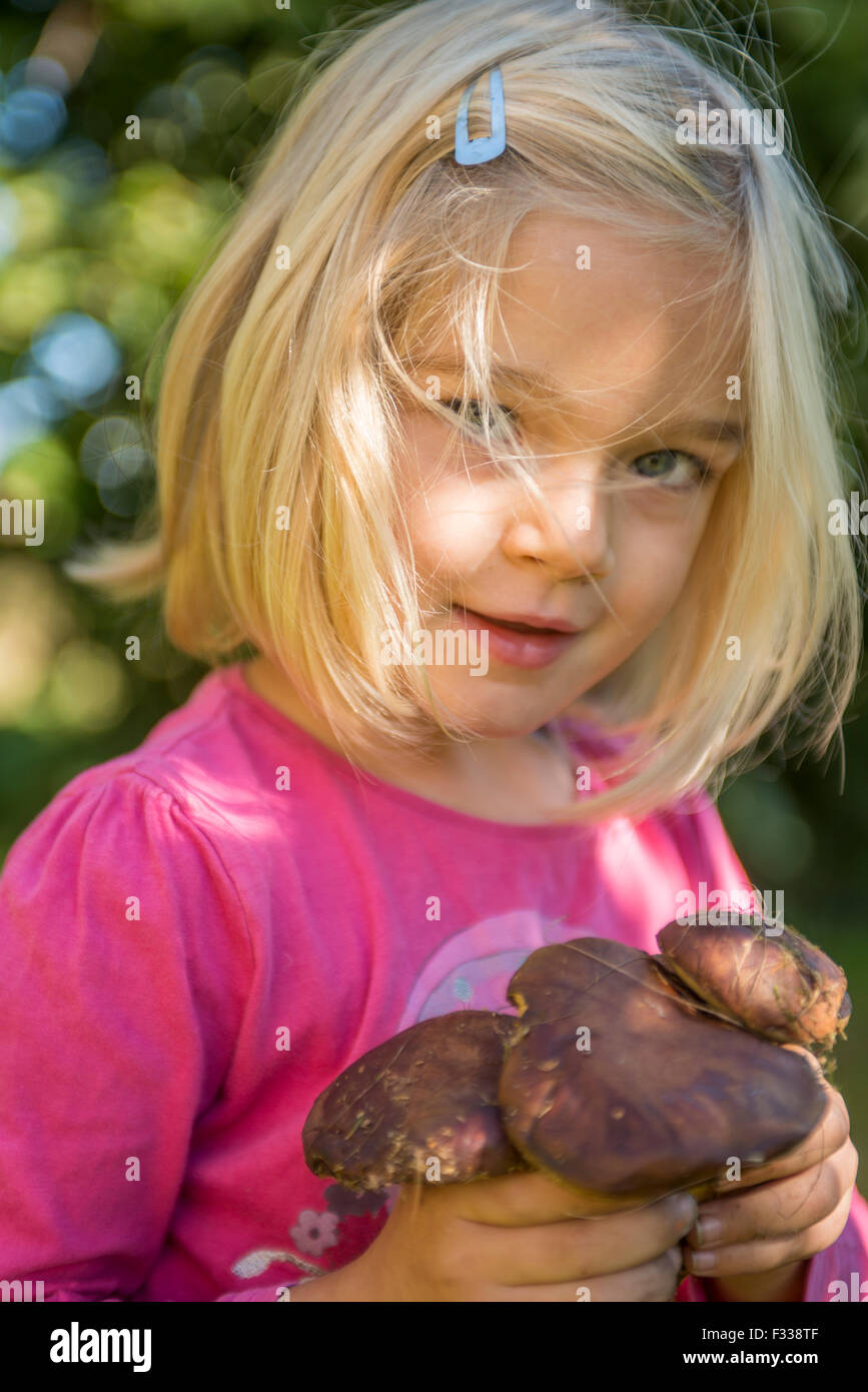 Portrait de jeune fille blonde enfant ramasser des champignons dans une forêt, se moquant, été, forêt, bois, des bois Banque D'Images