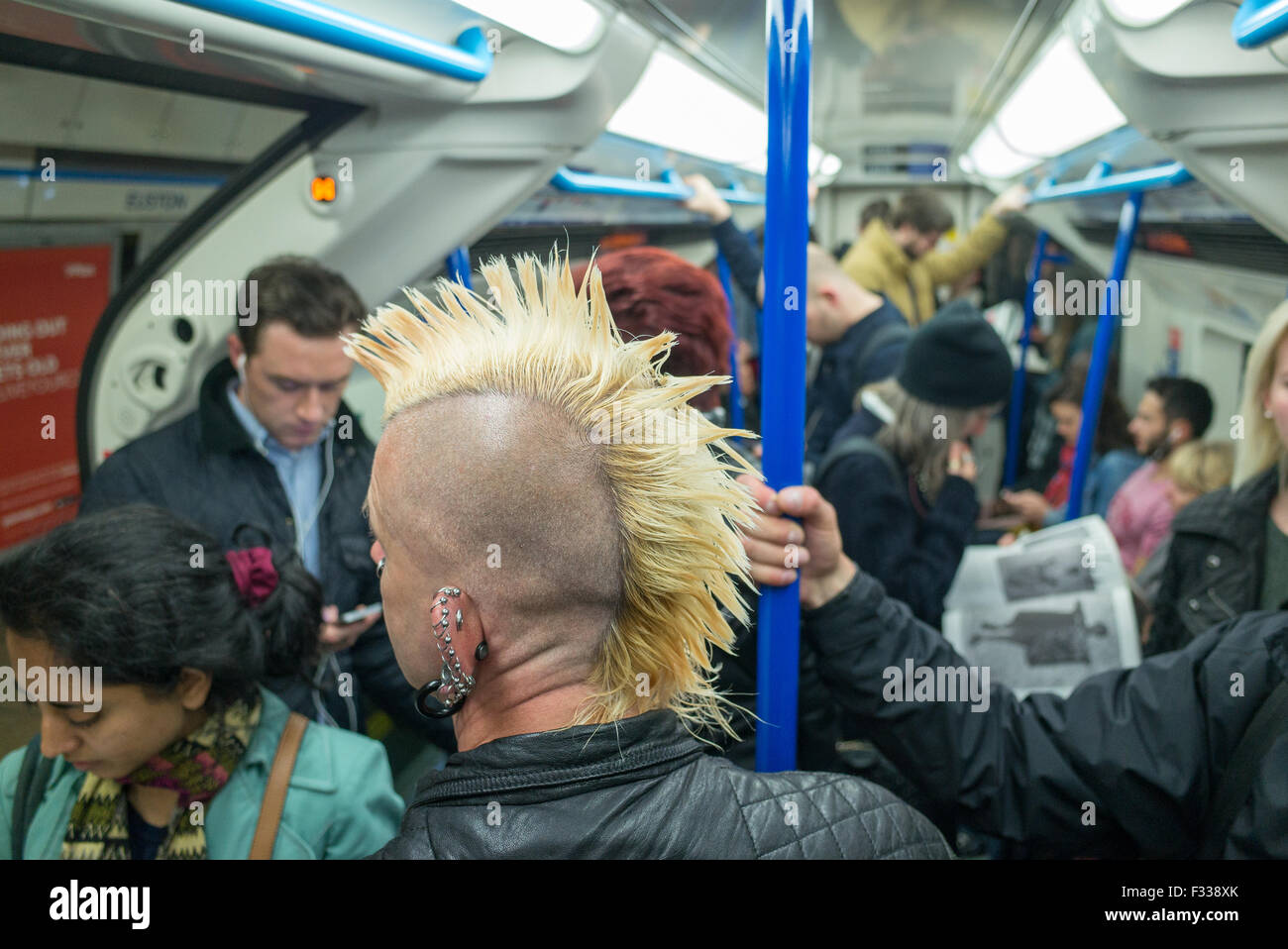 Un homme avec une coupe de Mohican sur un train de tube underground à Londres Grande-bretagne Banque D'Images