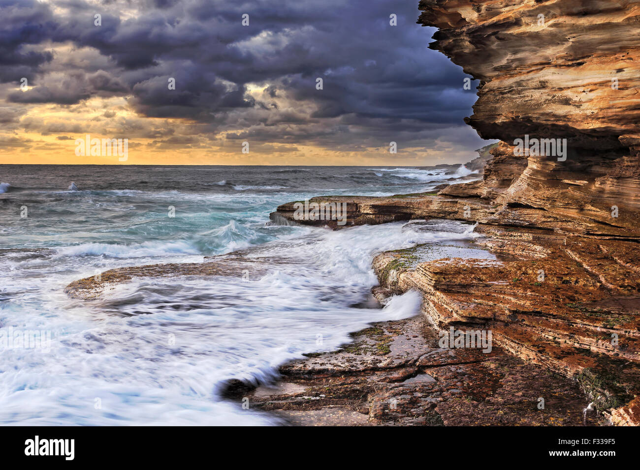 Océan Pacifique infinis saper rochers de grès des côtes australiennes près de Sydney durant une tempête lever du soleil Banque D'Images