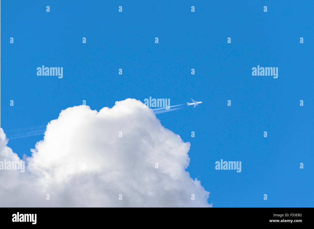 Un avion laissant une traînée de vapeur alors qu'il vole hors des nuages. Banque D'Images