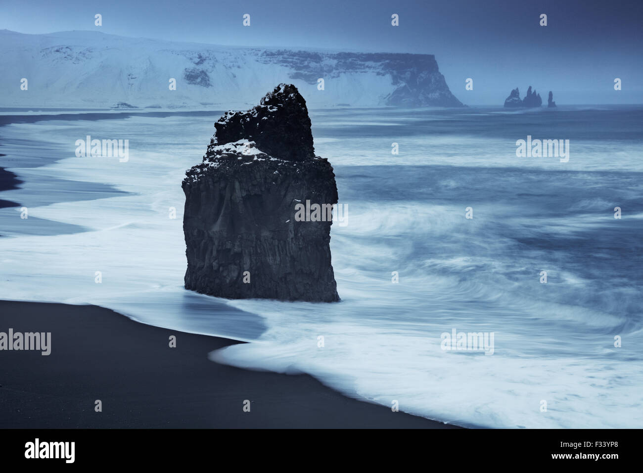 Vagues se brisant sur Reynisdranger avec Reynisfjara qui jouit, au-delà de l'Islande Banque D'Images Vagues se brisant sur Reynisdranger avec Reynisfjara qui jouit, au-delà de l'Islande Banque D'Images