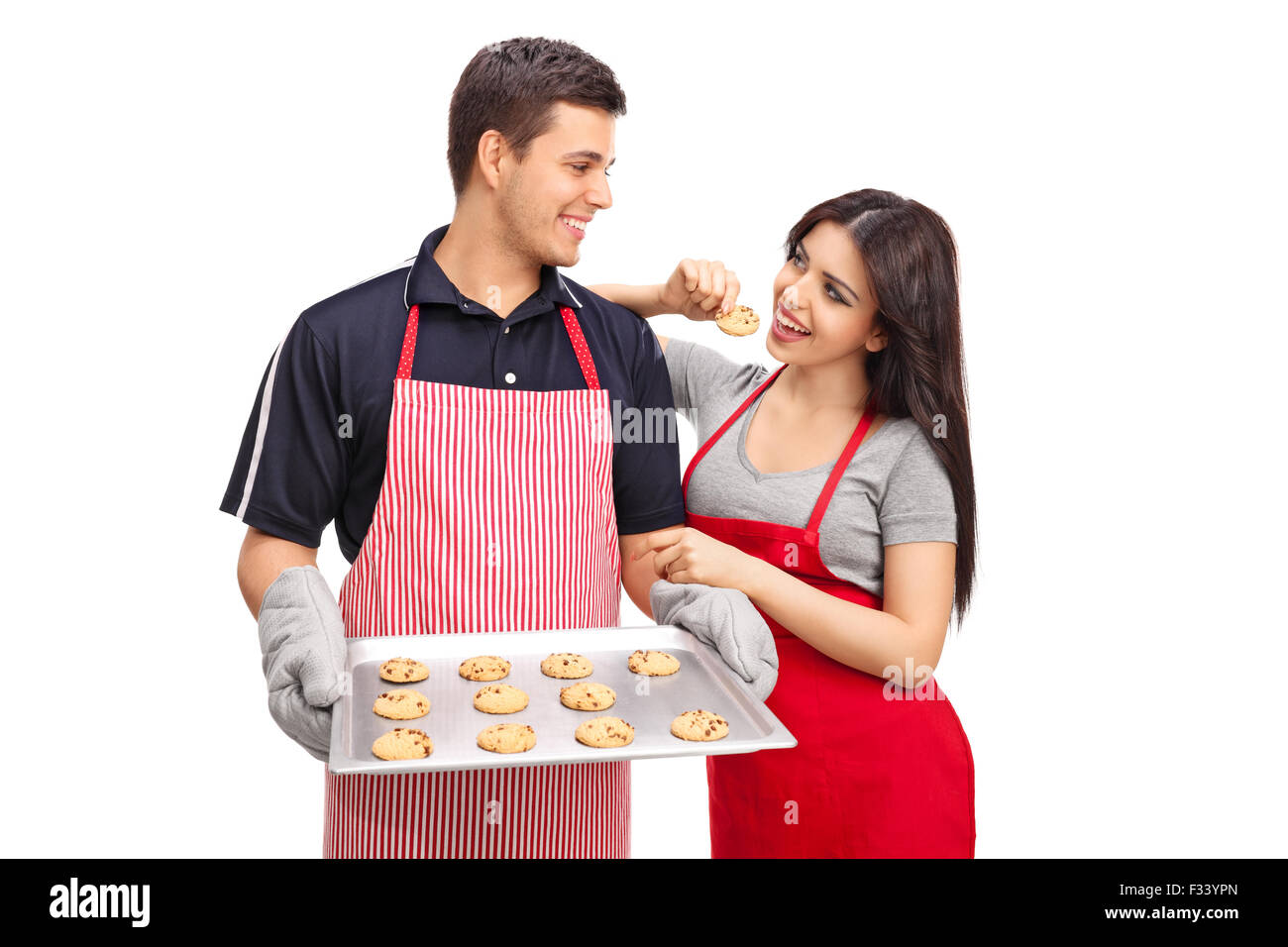 Studio shot of a young couple holding une casserole en aluminium avec chocolate chip cookies isolé sur fond blanc Banque D'Images