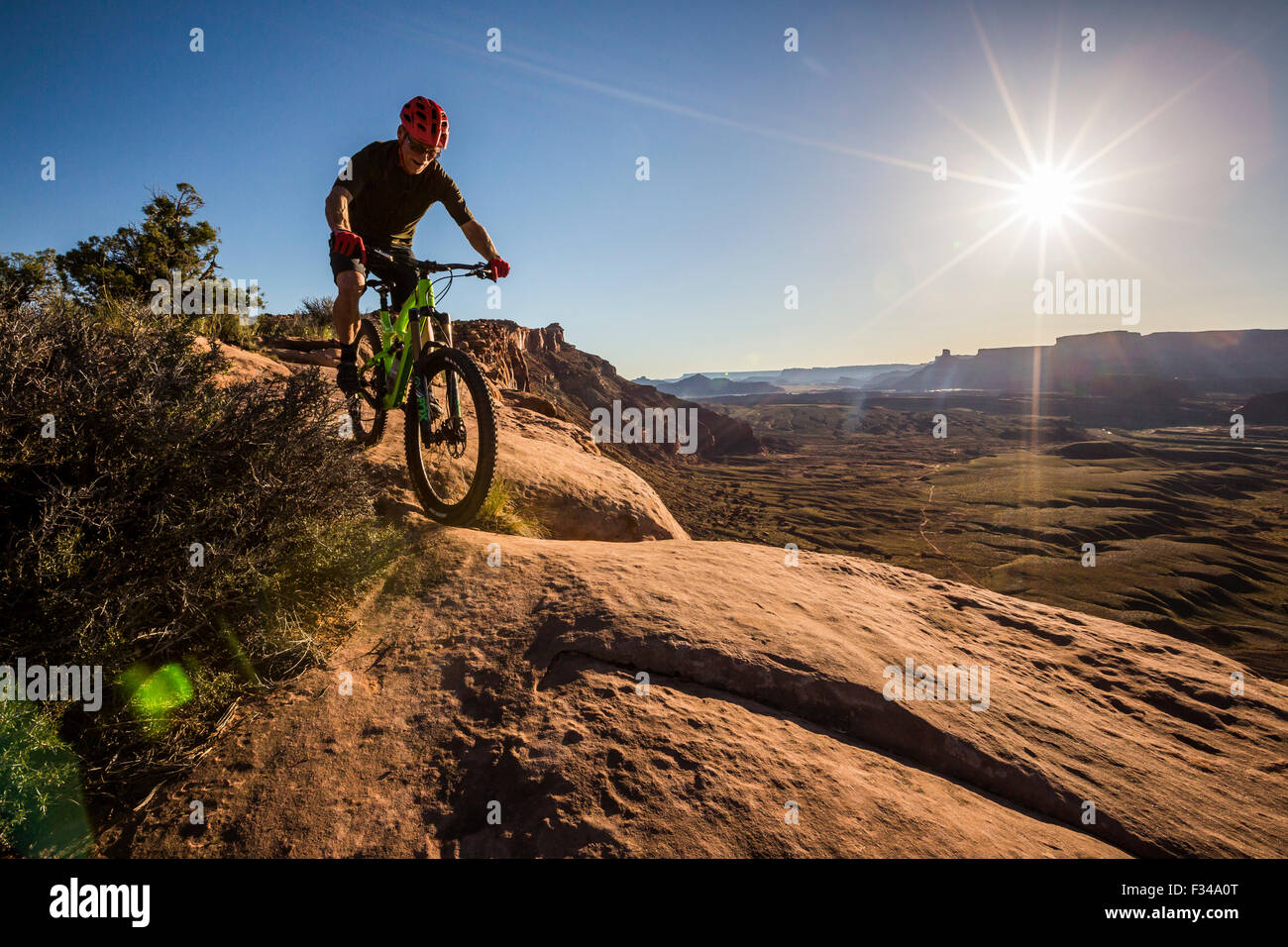 Homme vélo de montagne sur un sentier dans un environnement désertique au coucher du soleil. Banque D'Images