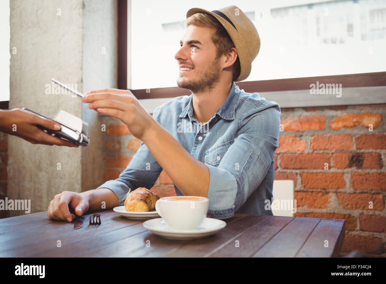 Beau hipster payer avec smartphone Banque D'Images