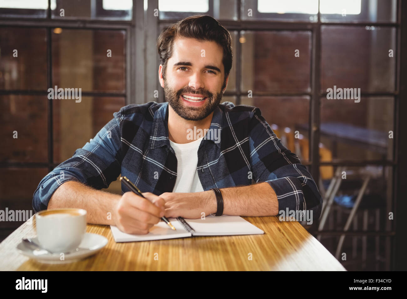 Jeune homme en prenant des notes dans son carnet Banque D'Images