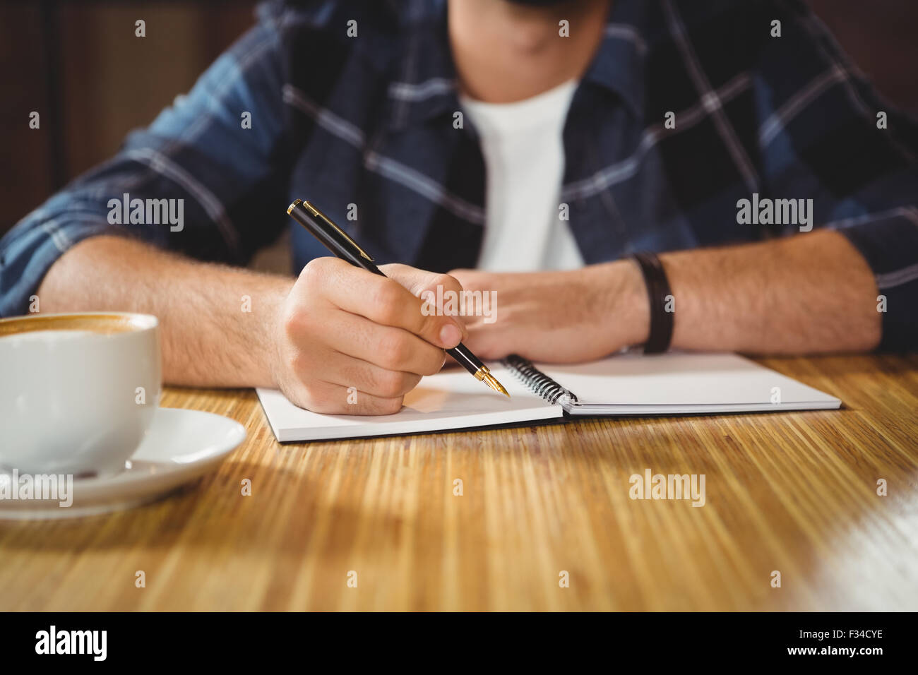 Jeune homme en prenant des notes dans son carnet Banque D'Images