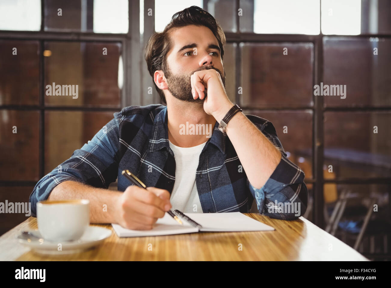 Jeune homme en prenant des notes dans son carnet Banque D'Images