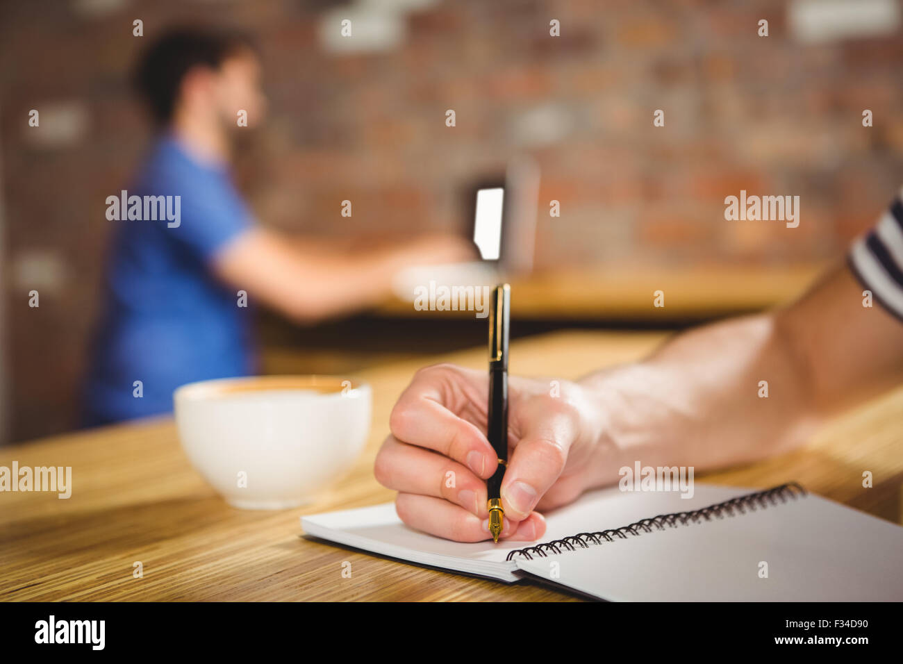 Jeune homme en prenant des notes dans son carnet Banque D'Images