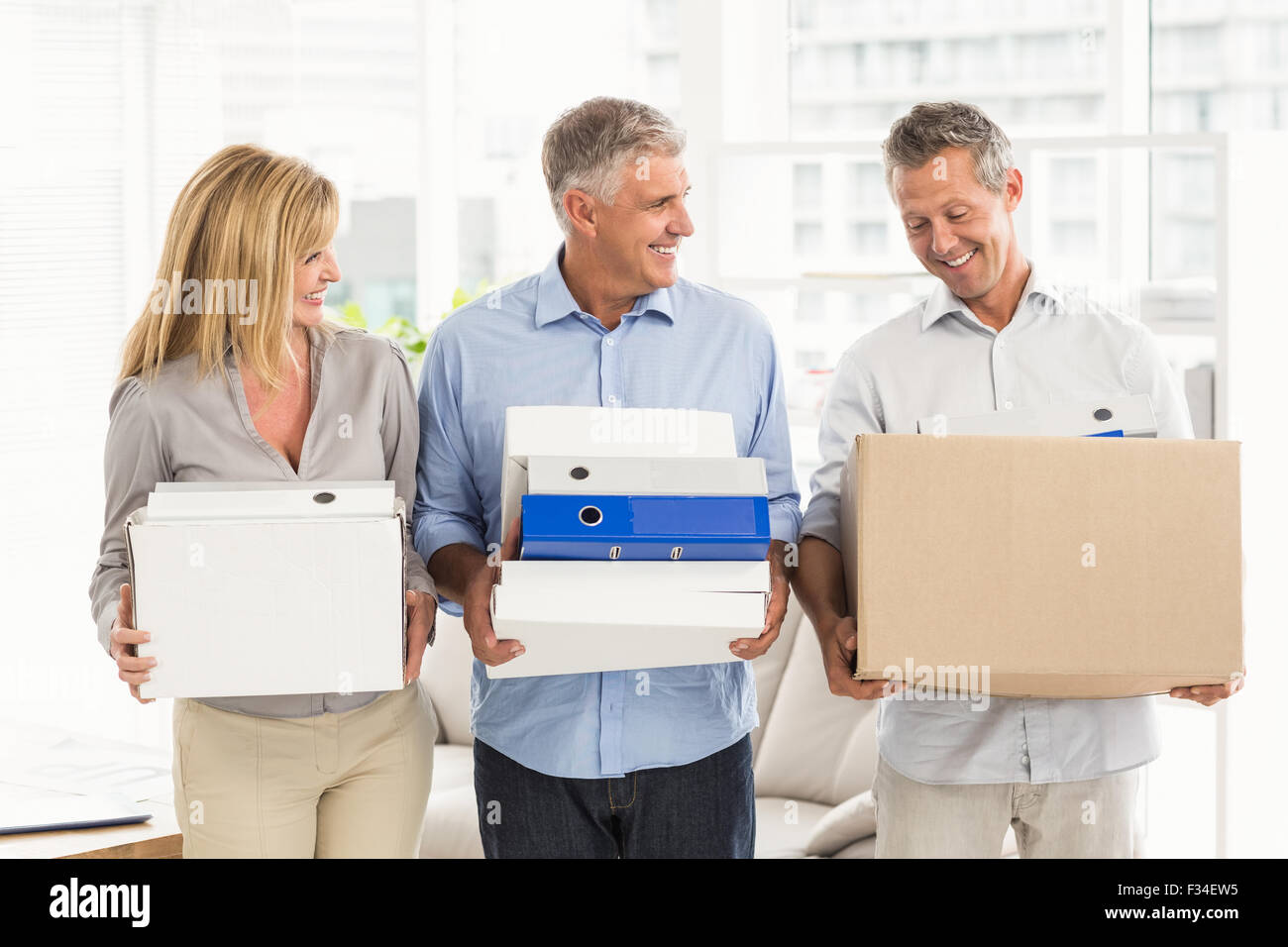 Casual business people talking et transporter cartons Banque D'Images