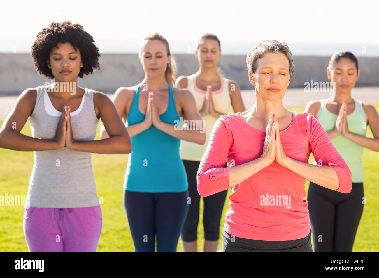 Les femmes sportive pacifique faisant la prière en position de yoga Banque D'Images