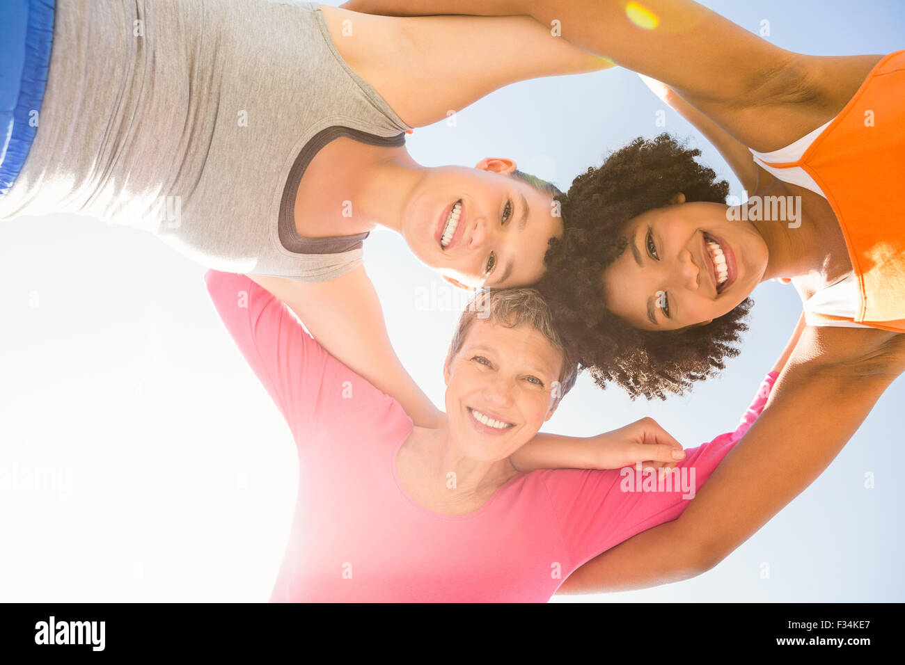 La femme sportive avec les bras autour de souriant à l'appareil photo Banque D'Images