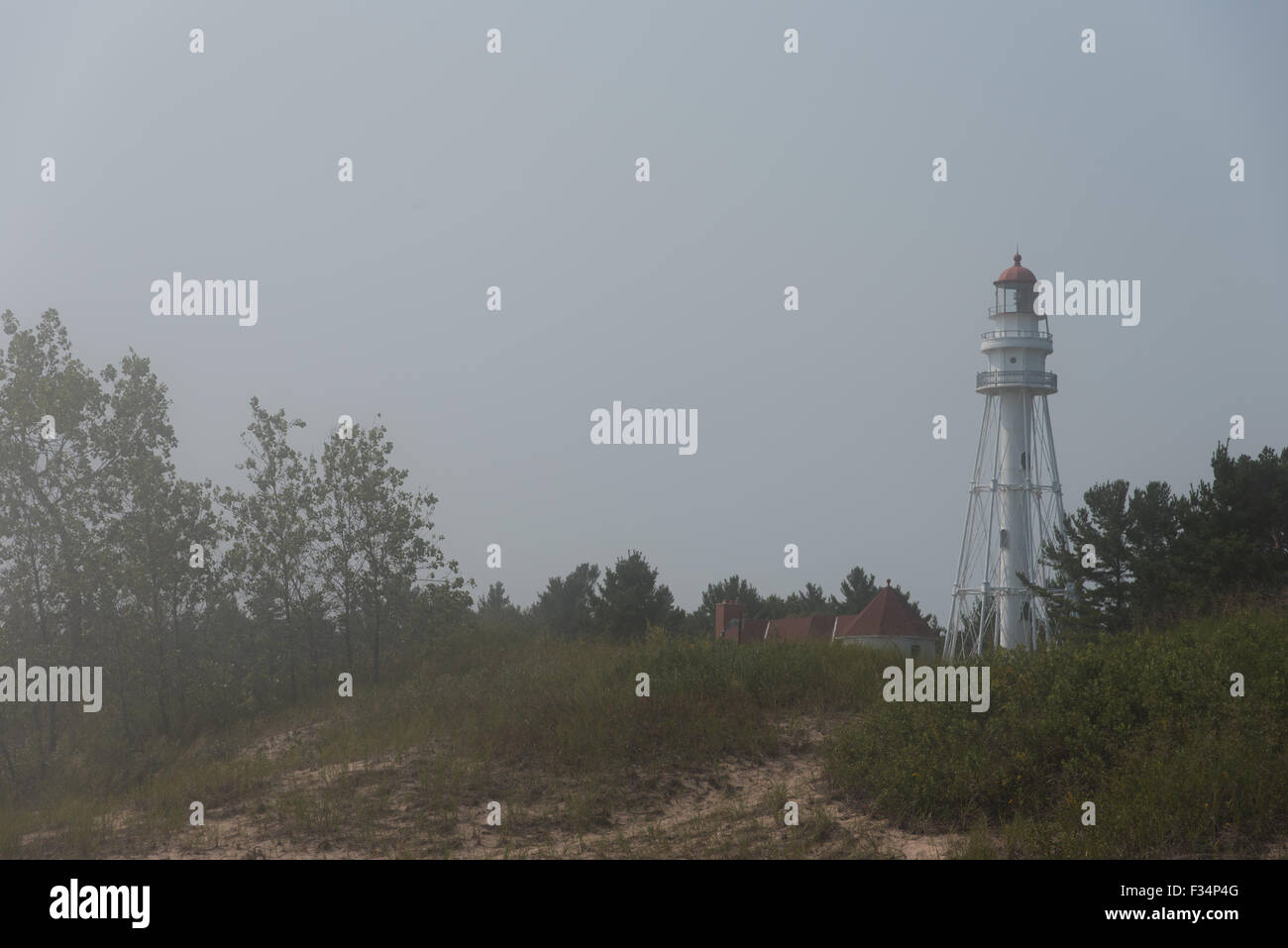 Rawley Point Lighthouse, situé juste à côté de la plage du lac Michigan, partiellement masquée par un épais brouillard qui est venu de la cool Banque D'Images