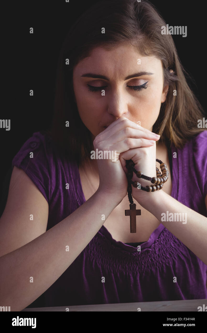 Femme en prière avec le chapelet en bois Banque D'Images