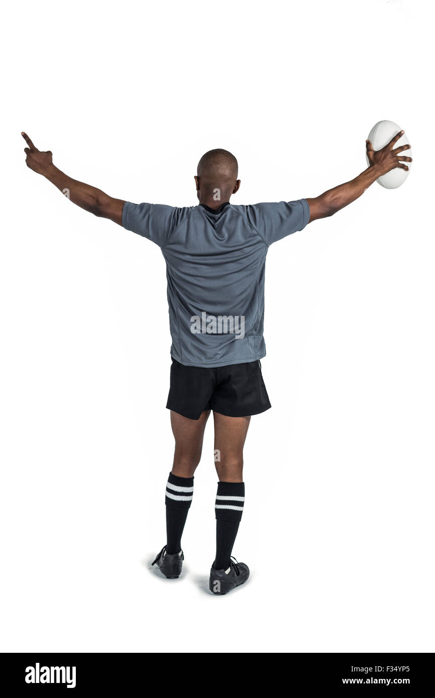 Vue arrière de l'athlète les bras levés holding rugby ball Banque D'Images