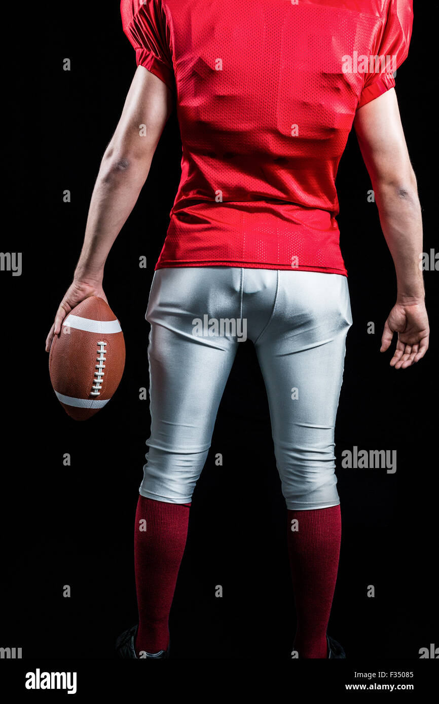 Mid section of American football player with ball Banque D'Images