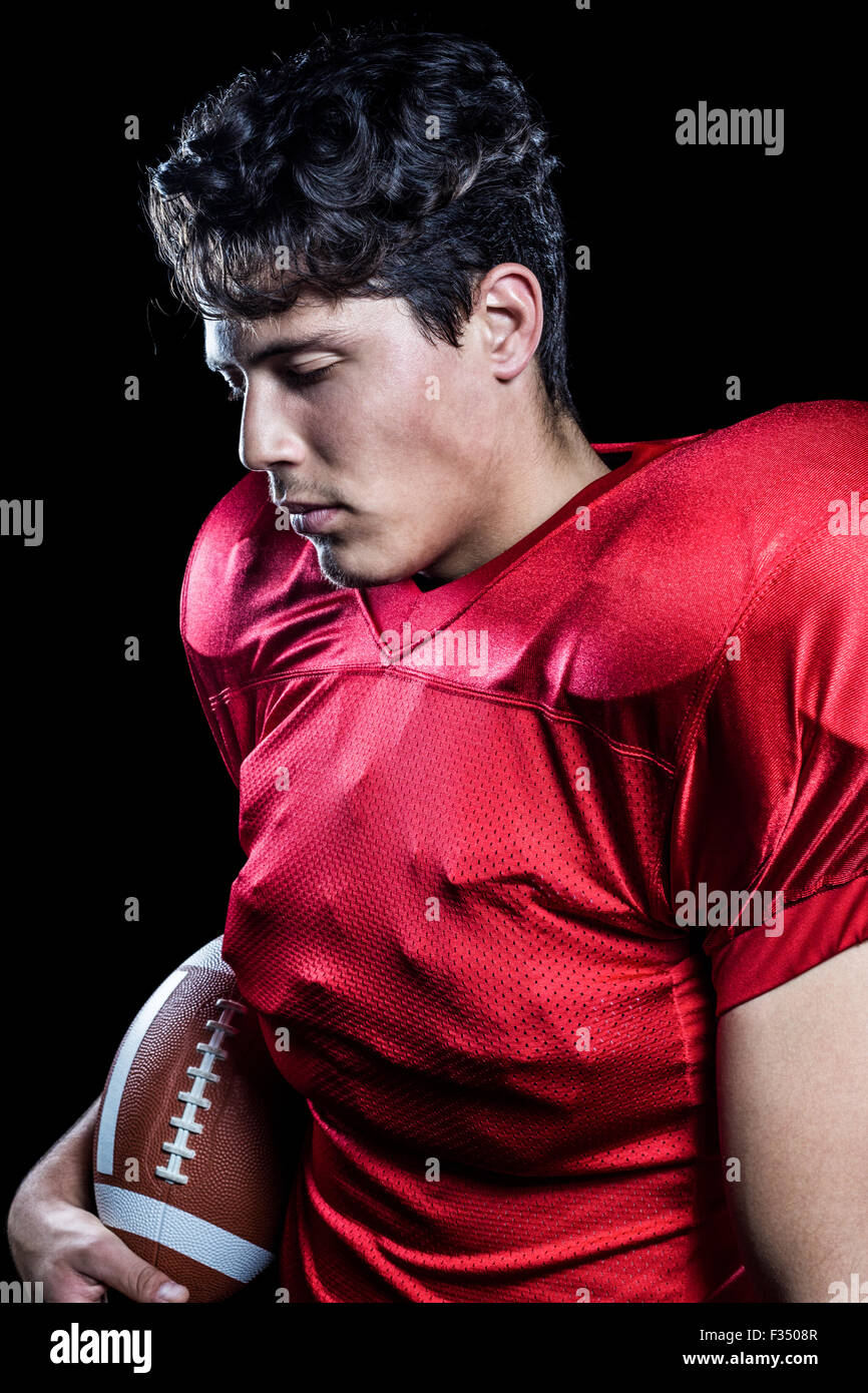 American football player holding ball tandis que les yeux fermés Banque D'Images