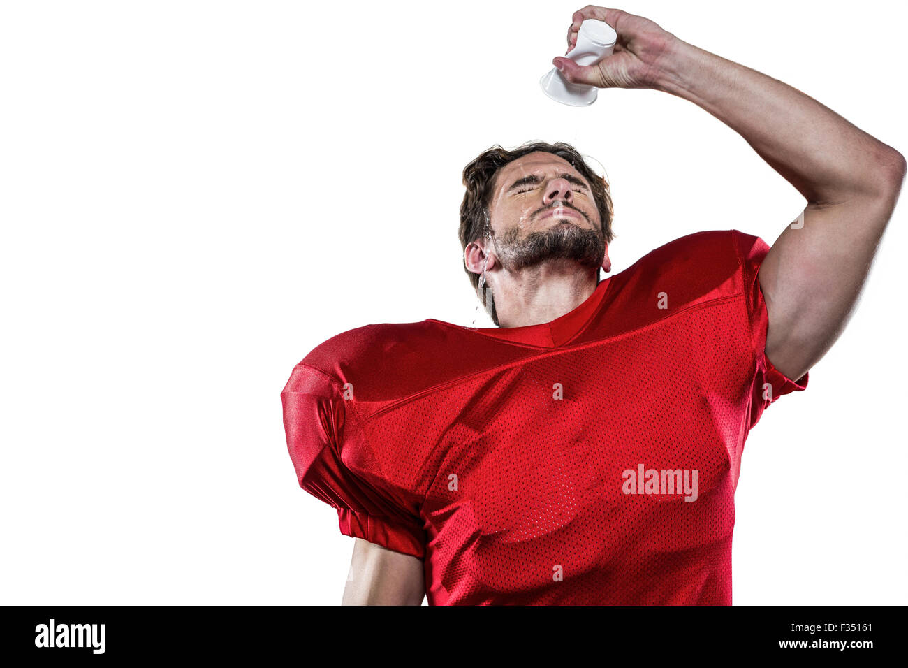 Joueur de football américain en maillot rouge verser de l'eau sur le visage Banque D'Images