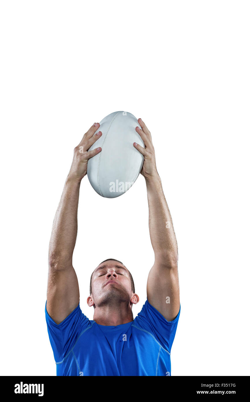 Rugby player holding ball avec les yeux fermé Banque D'Images