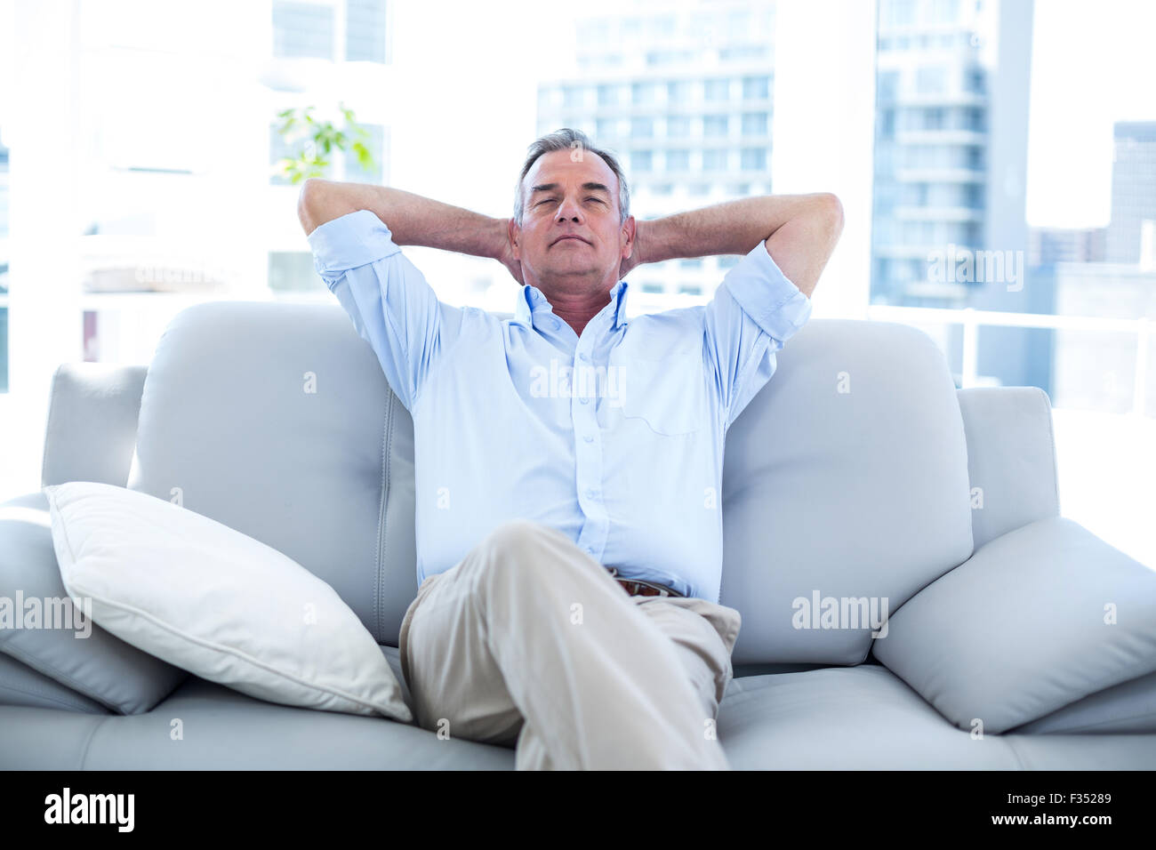 Man relaxing on sofa at home Banque D'Images