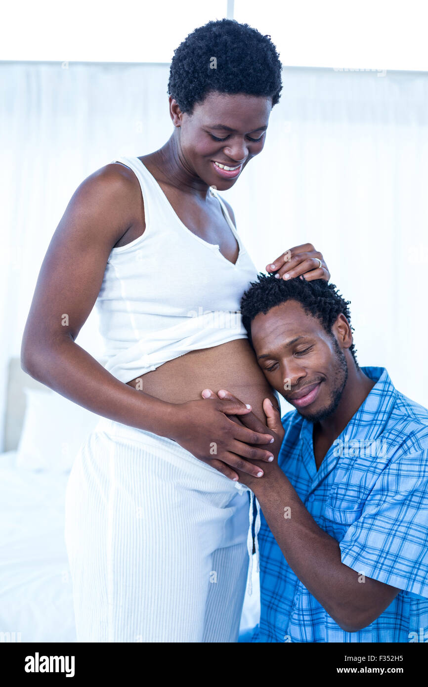 Mari L'écoute de sa femme enceinte ventre Banque D'Images