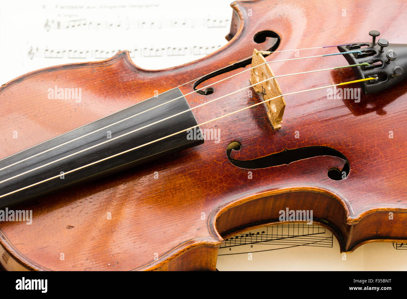 Close up of a Thouvenel, Paris, violon, vers 1800, sur fond de musique en feuilles, montrant principalement avec le corps de pont et F-trous, Banque D'Images