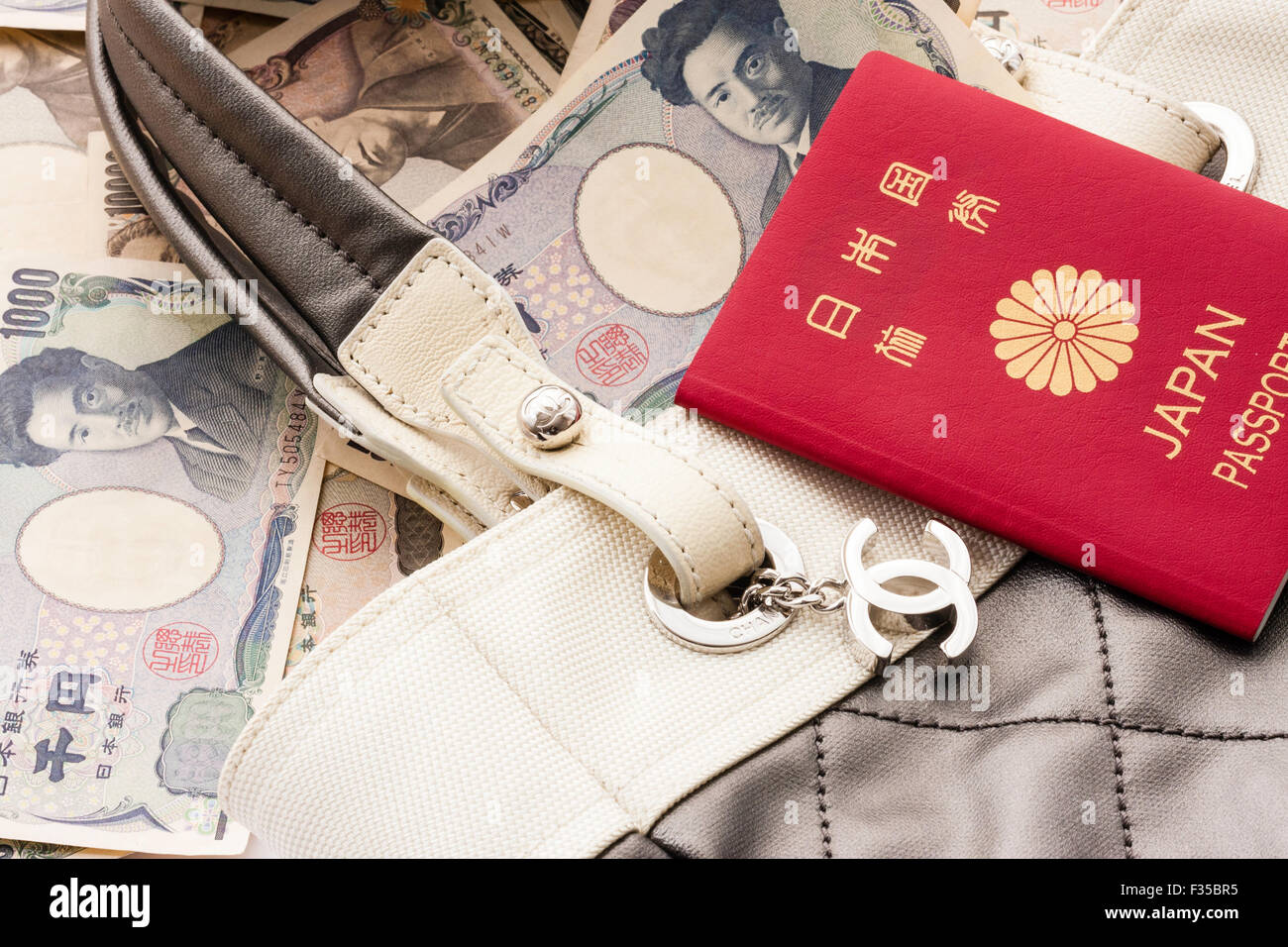 Close up detail d'un nom de marque Chanel sac de créateur avec son logo métal tag, CC, et de passeport et billets de Yen japonais Banque D'Images
