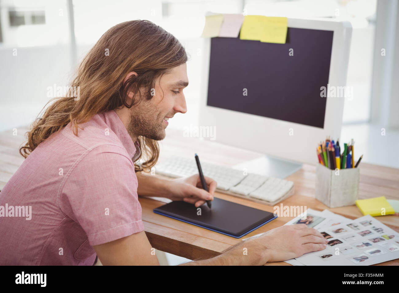 À l'aide d'Hipster tablette graphique tout en travaillant au bureau Banque D'Images