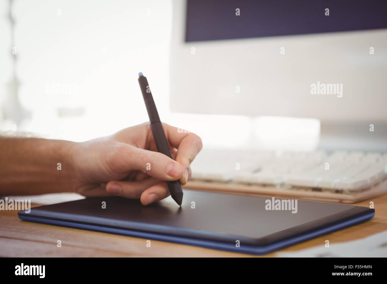 Cropped main de l'homme travaillant sur tablette graphique Banque D'Images