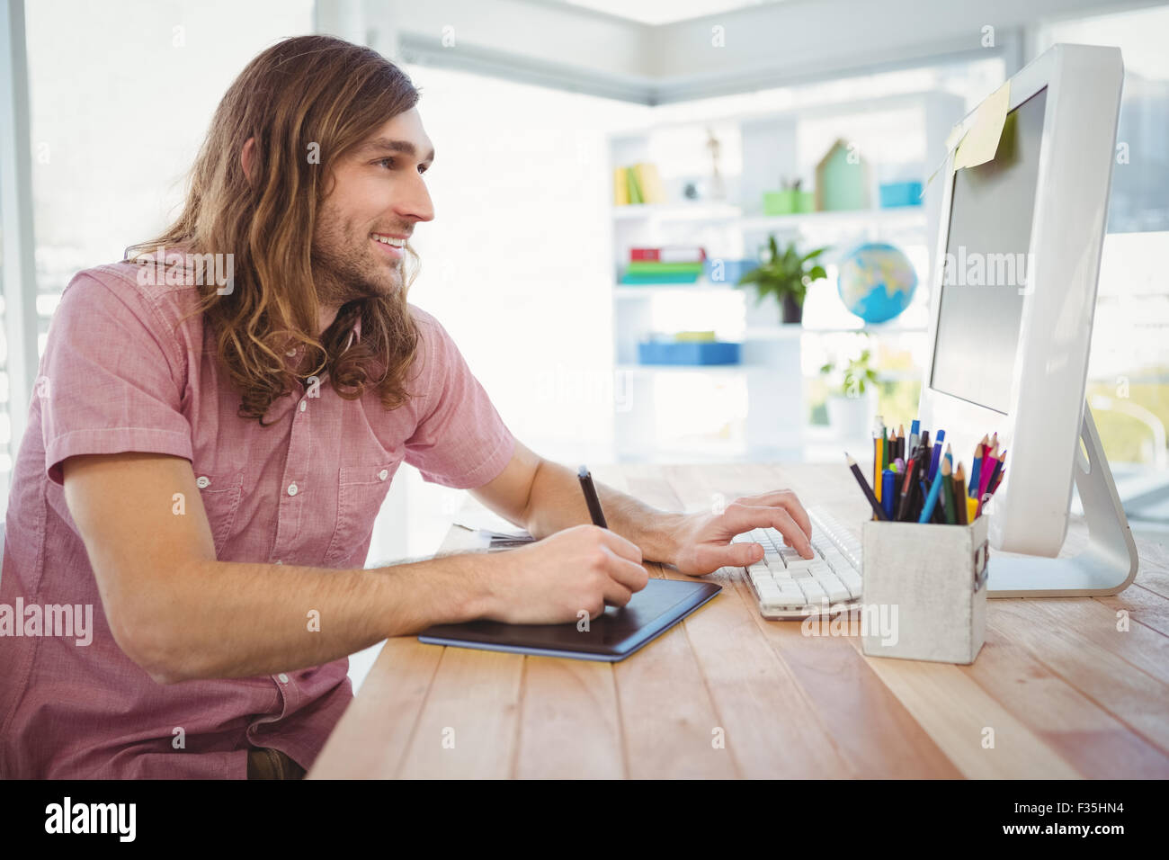 Hipster travaillant sur tablette graphique et l'ordinateur Banque D'Images