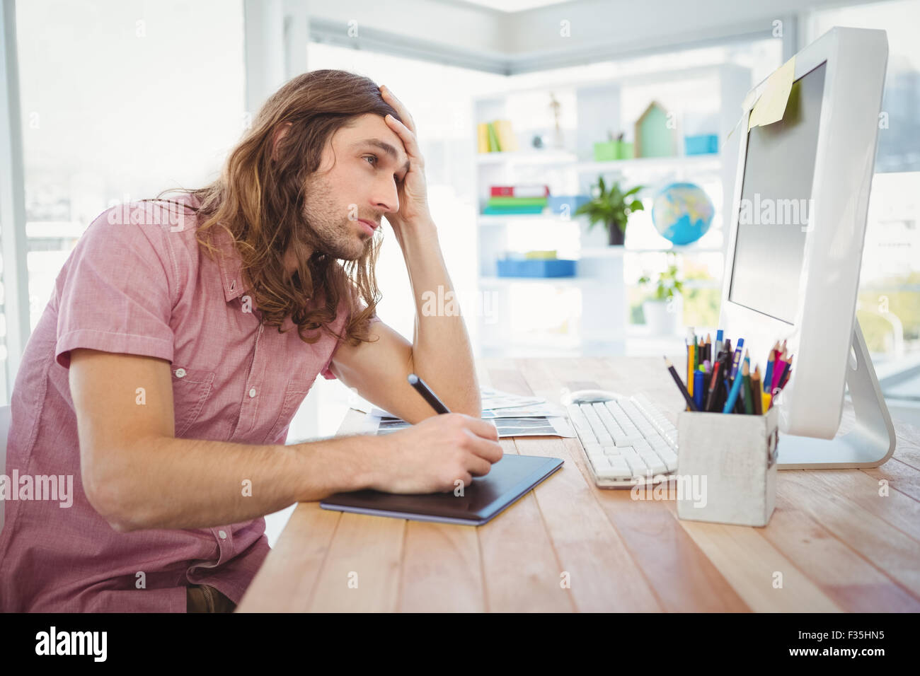 Hipster fatigué de travailler sur tablette graphique et l'ordinateur Banque D'Images
