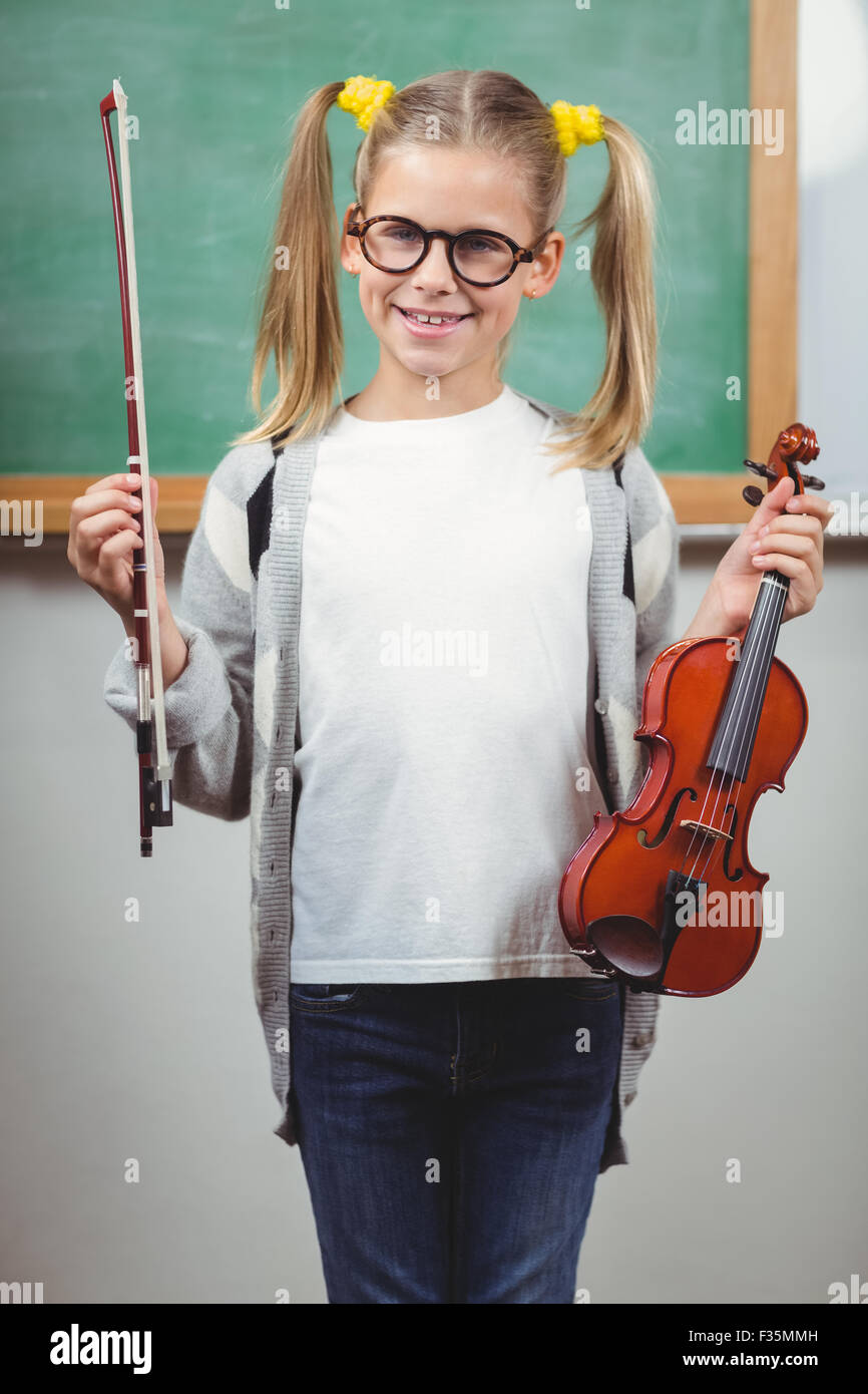 Cute élève holding violin in a classroom Banque D'Images